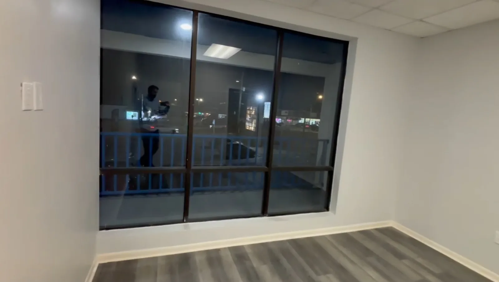 A real Faithful Cleaning Service job - a finished commercial office suite with a fresh laminate floor, clean baseboards and a large storefront window, cleaned and ready for move-in